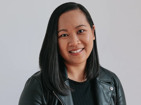 Smiling woman with long black hair wearing a dark leather jacket